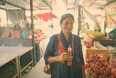 Portrait of smiling young woman holding food