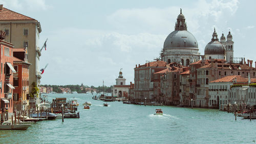 View of the boats sailing on the grand canal in venice with the dome in the background.