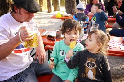 Rear view of friends sitting on the road