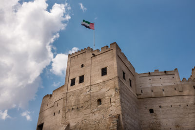 Low angle view of building against cloudy sky