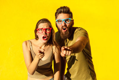 Portrait of young couple against yellow background
