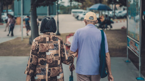 Rear view of couple walking on footpath