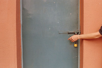 Midsection of person holding closed door