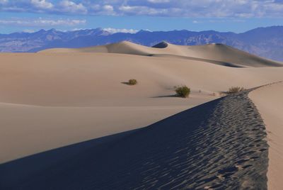 Scenic view of desert against sky during sunny day