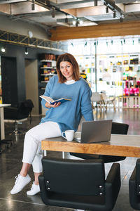 Beautiful stylish young woman plus size body positive using laptop at beauty salon office