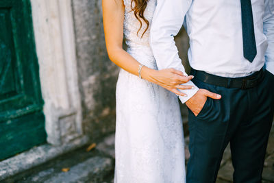 Rear view of couple standing against brick wall