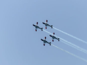 Low angle view of airshow against clear sky