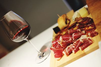 Close-up of food in plate on table. cold cut and a glass of wine