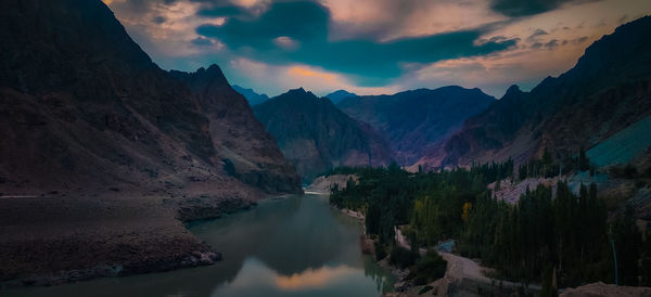 Panoramic view of lake amidst mountains against sky during sunset