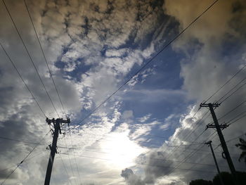 Low angle view of silhouette electricity pylon against sky