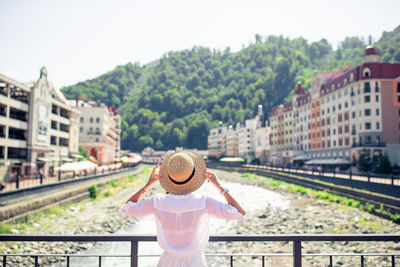 Rear view of woman standing at park against sky