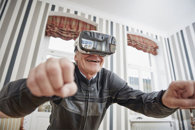 Senior man in motorcycle suit wearing vr glasses