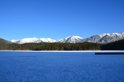 Scenic view of snowcapped mountains against clear blue sky