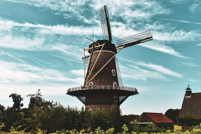 Low angle view of traditional windmill against sky