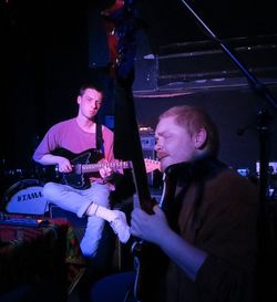 Two men playing guitar at music concert