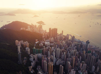 Aerial view of modern buildings in city during sunset