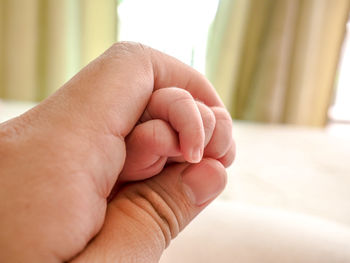 Close-up of hands holding baby hand