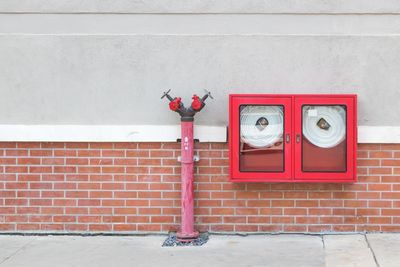 Red fire hydrant against wall