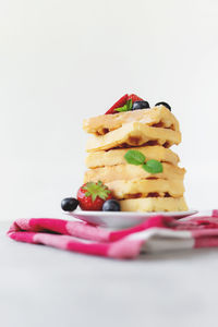 Close-up of cake in plate against white background