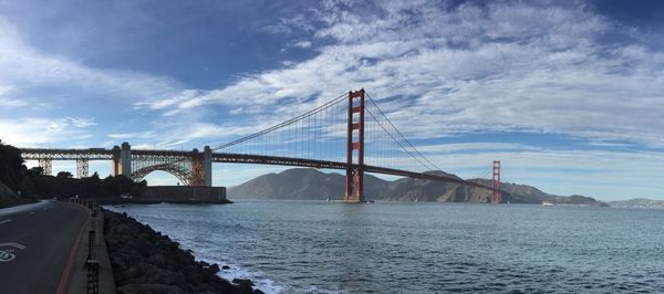 View of suspension bridge against cloudy sky