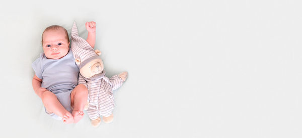 Portrait of cute baby boy lying on bed at home