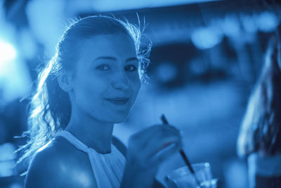 Close-up portrait of young woman having drink while standing outdoors