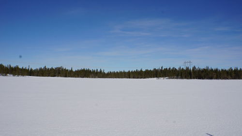 Scenic view of snow covered field against sky