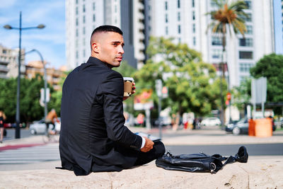 Side view of young man on street in city