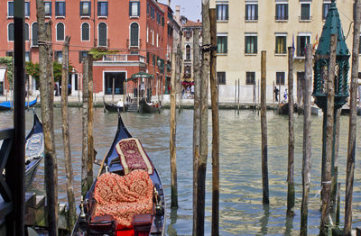 Boats moored in canal against buildings in city