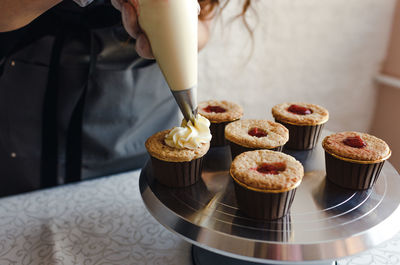 Midsection of man preparing cake on table