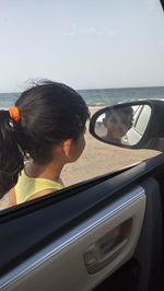 Portrait of man driving car by sea against sky