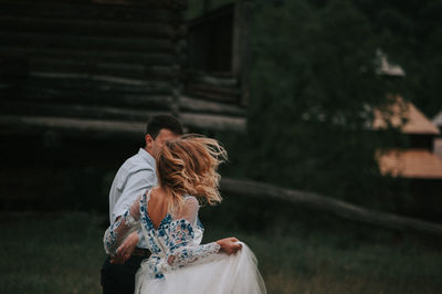 Couple running on grass against sky