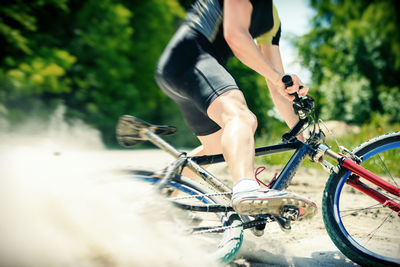 Low section of woman riding bicycle