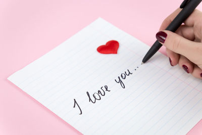 Close-up of hand holding paper with text