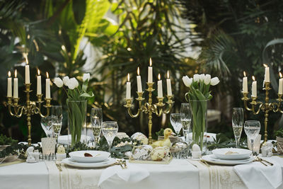 Candles with place setting on dining table in yard