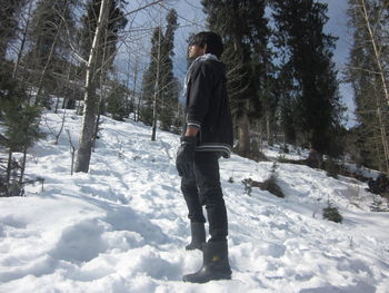 Man standing on snow covered trees