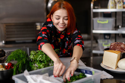 Young woman having food in kitchen