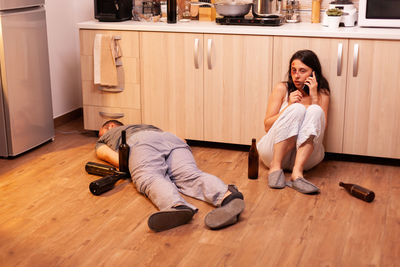 Portrait of woman sitting on hardwood floor at home