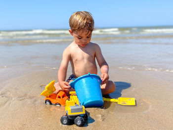 Boy playing with sand at beach