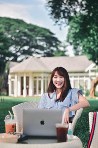 Portrait of a smiling young woman using mobile phone