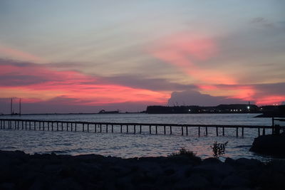 Scenic view of calm sea against cloudy sky during sunset