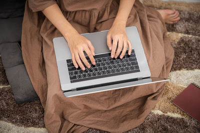 Midsection of woman using laptop