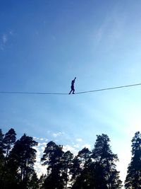 Low angle view of silhouette person tightrope walking