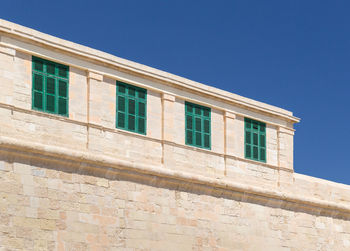 Low angle view of building against clear blue sky