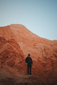 Rear view of man standing on rock formation