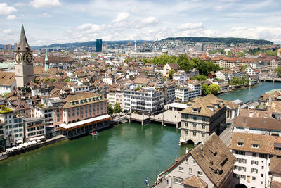 High angle view of river amidst houses in town against sky