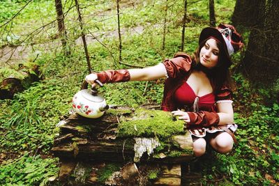 Young woman smiling while holding tree