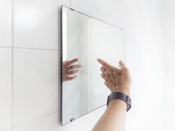 Close-up of woman hand on white wall