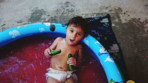 High angle portrait of cute girl with toy in wading pool