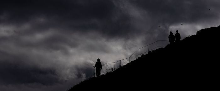 Low angle view of silhouette building against cloudy sky